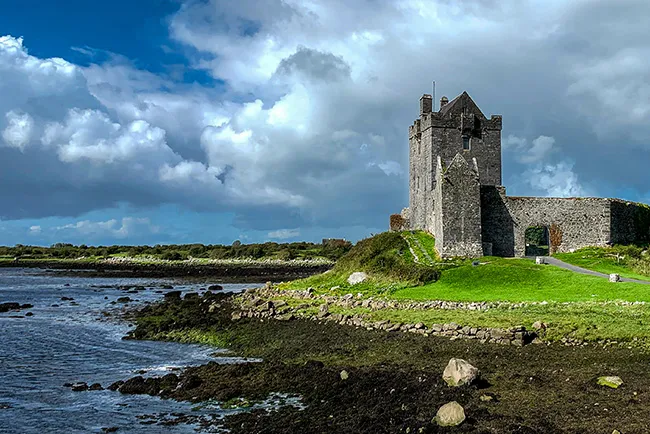 Tower house beside the shore under a cloudy sky